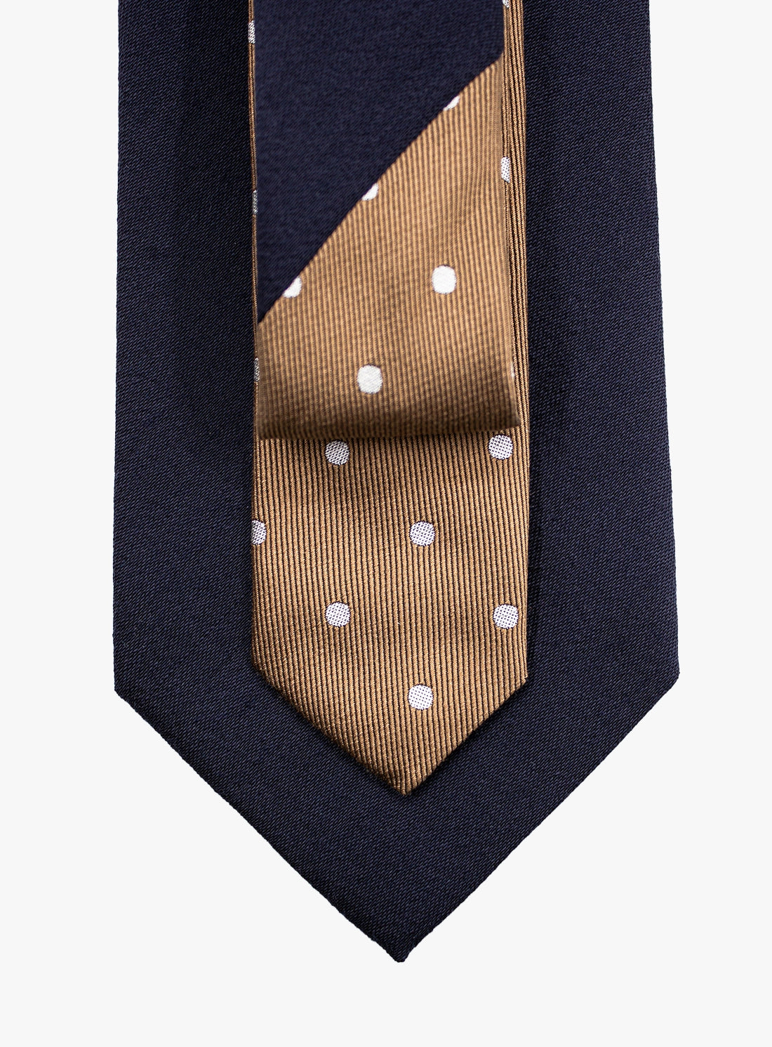 Navy blue tie with a brown section featuring white polka dots on a white background