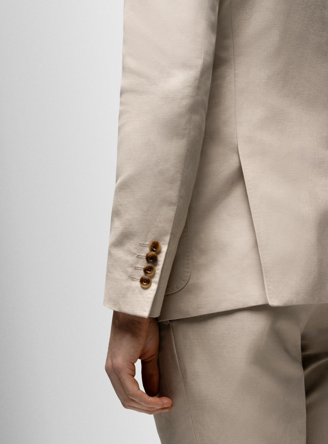 Beige suit jacket with buttons on a light gray background