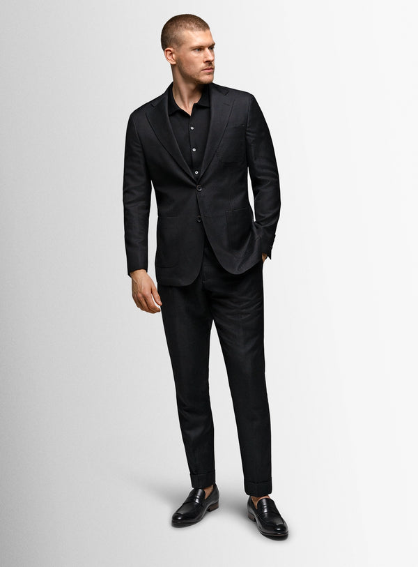Man wearing a black suit on a light gray background