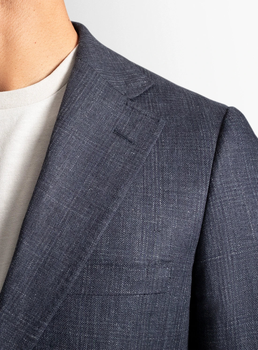 Close-up of a blue checkered suit jacket on a plain background
