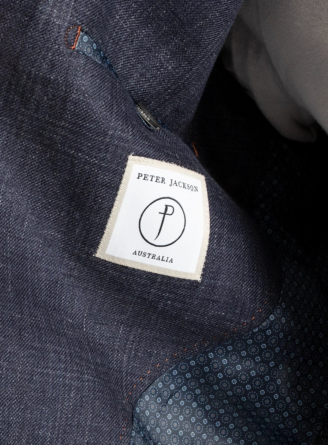 Close-up of a denim fabric with a 'Peter Jackson Australia' label.
