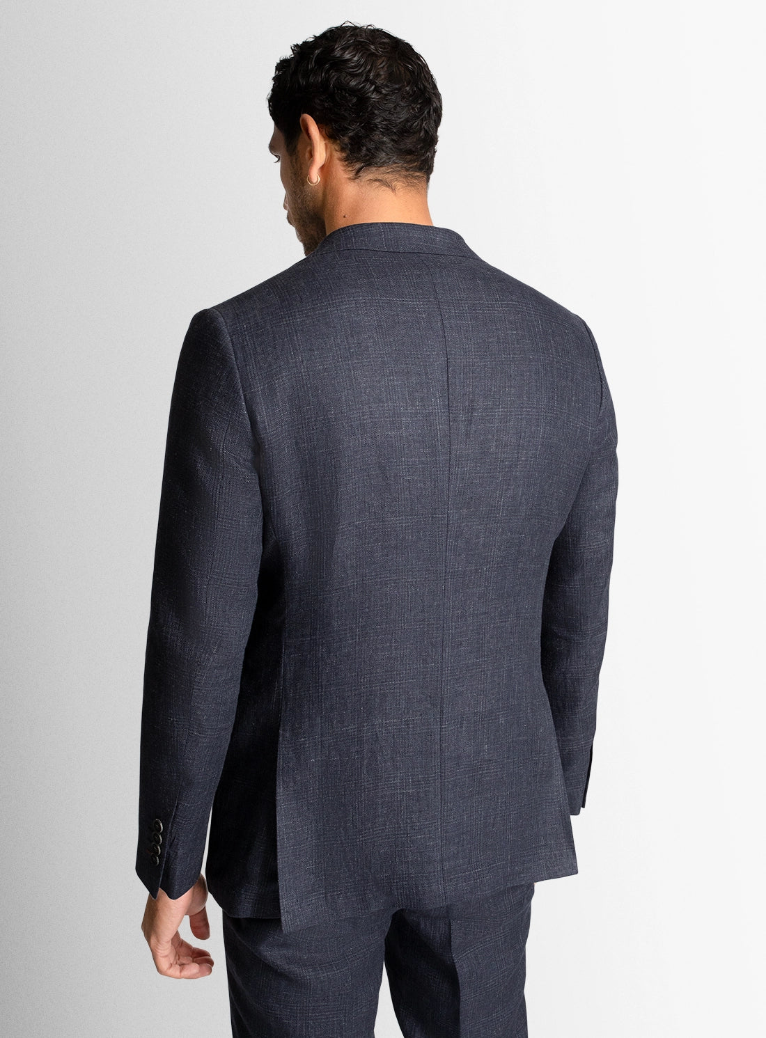 Man wearing a gray suit jacket on a plain background