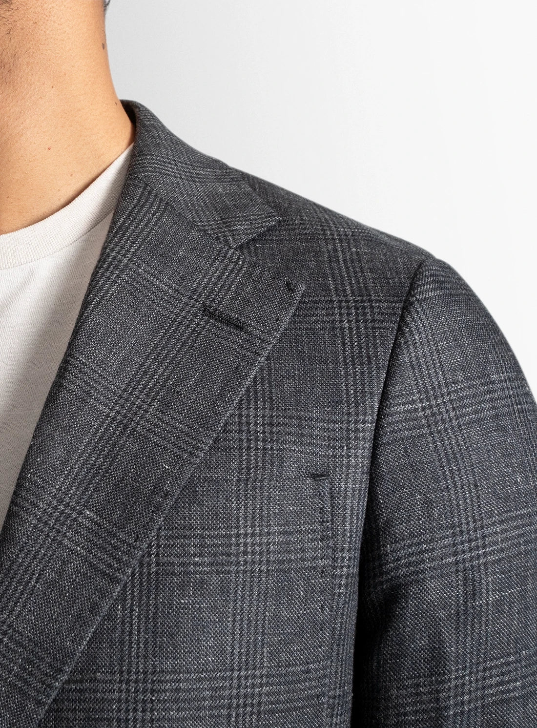 Gray checkered blazer worn by a person on a white background
