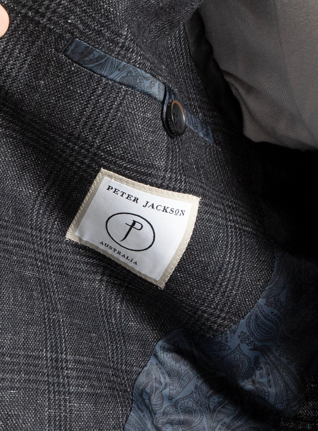 Close-up of a textured fabric with a brand label on a dark background