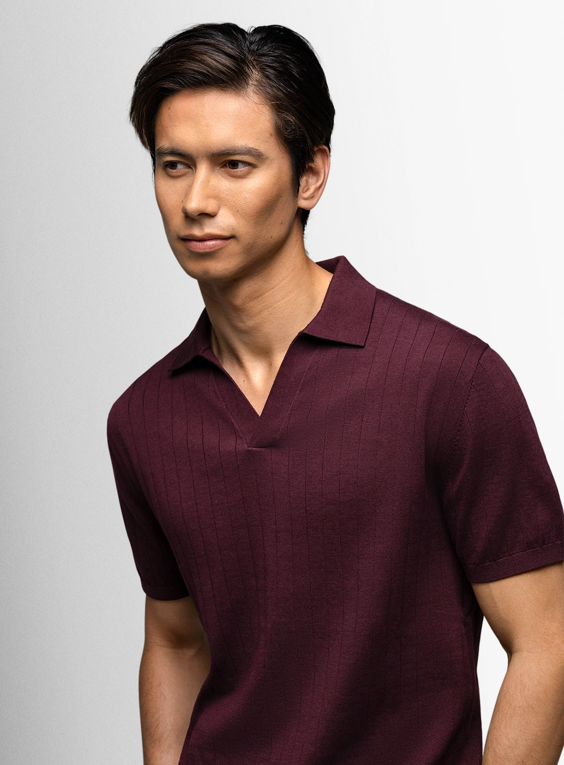 Man wearing red polo shirt against white background