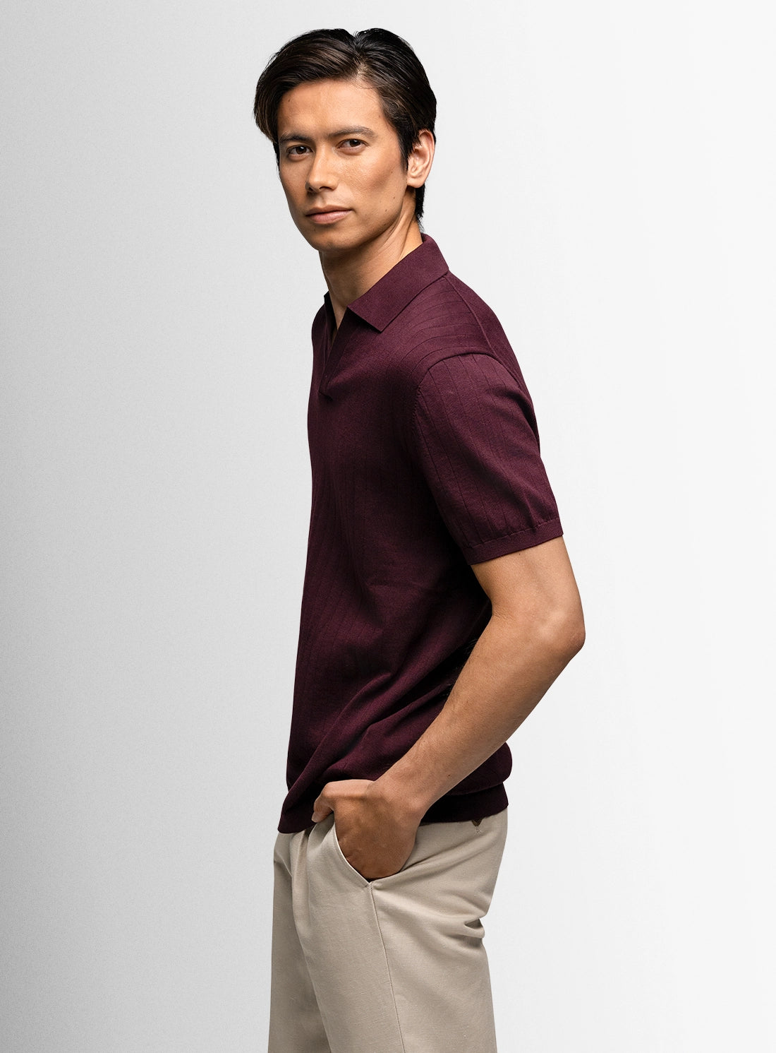 Man wearing a red polo shirt with beige on a white background