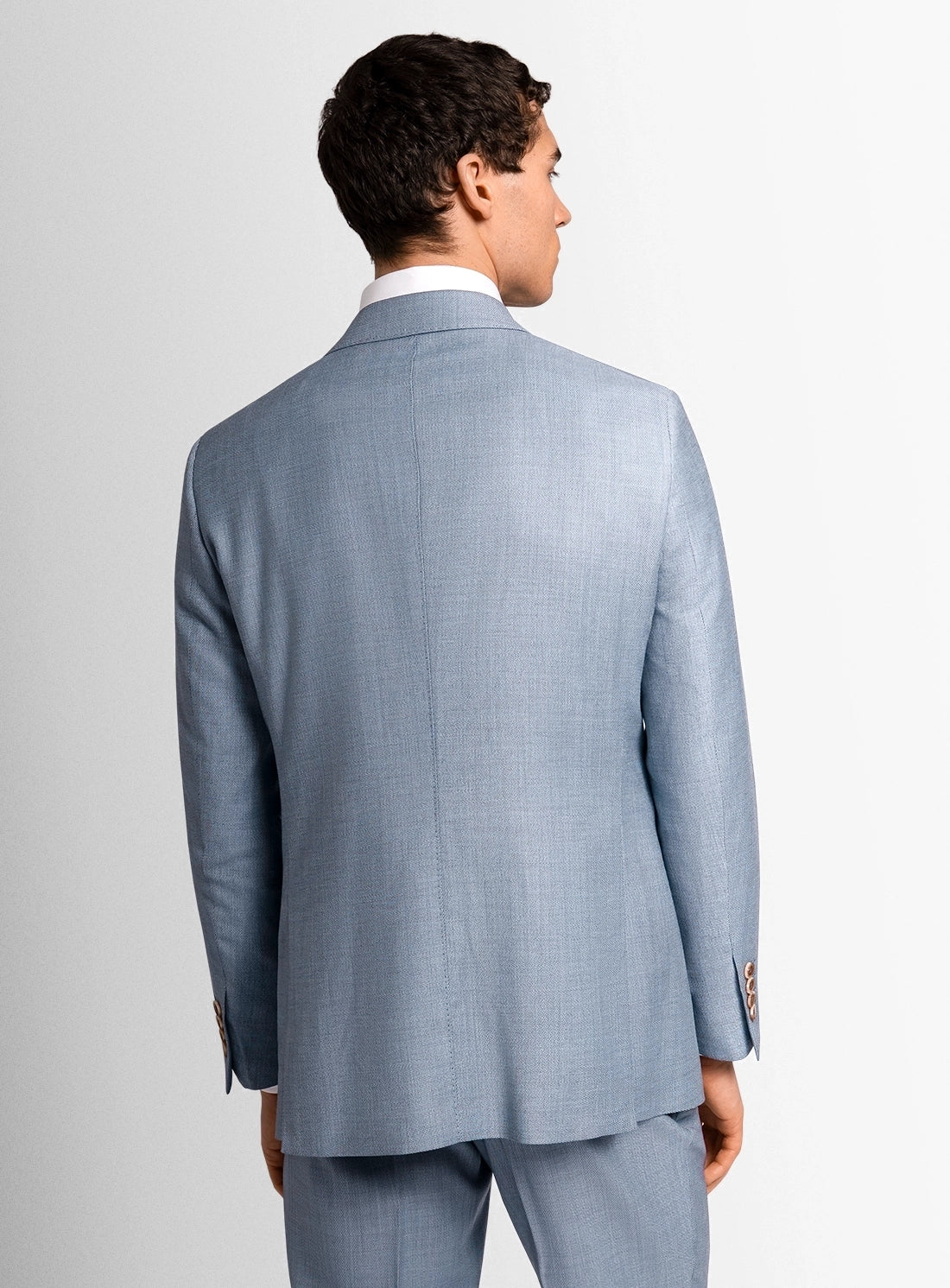 Man wearing a light blue suit on a plain background