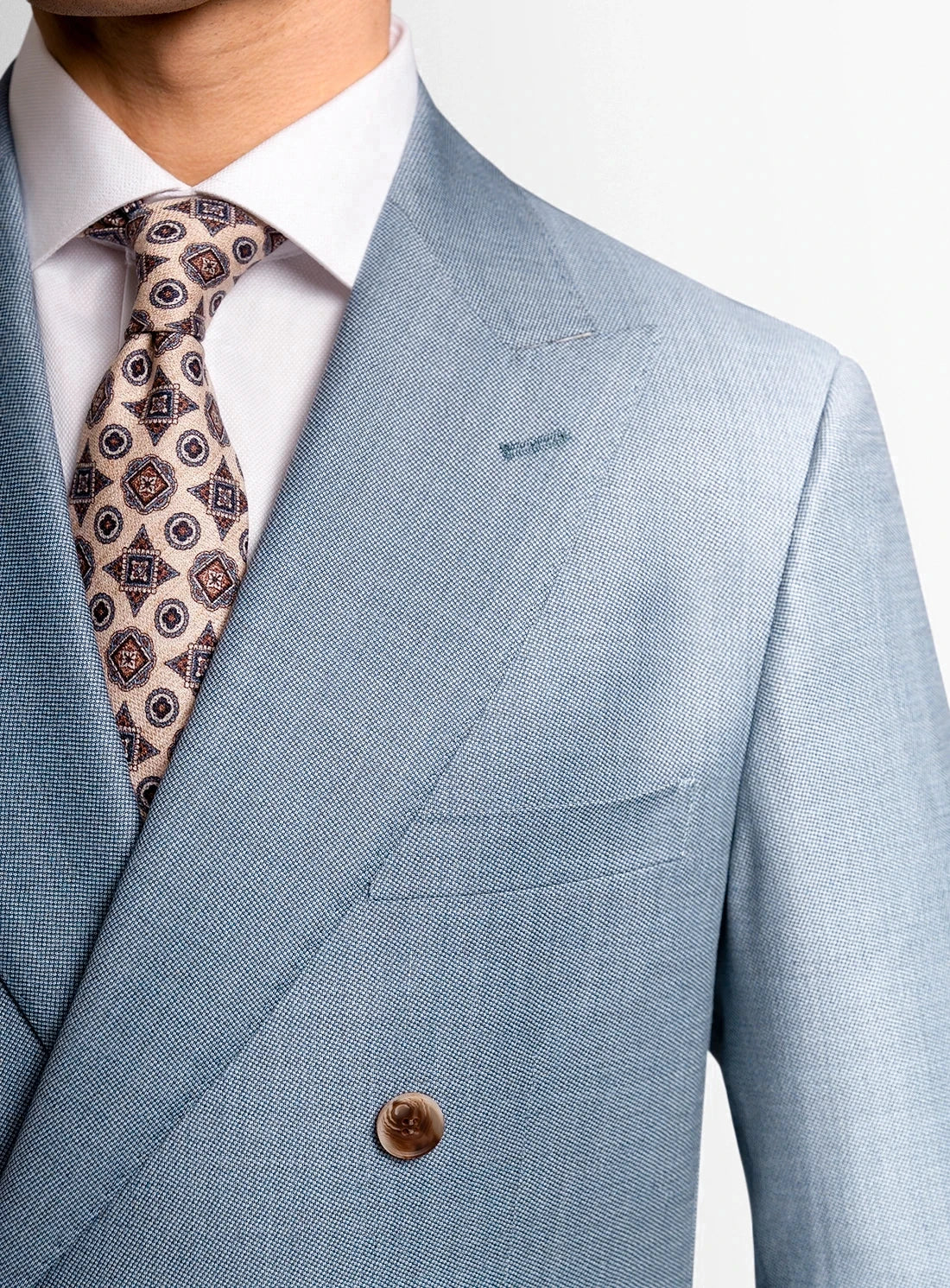 Light blue suit jacket with a patterned tie on a white background