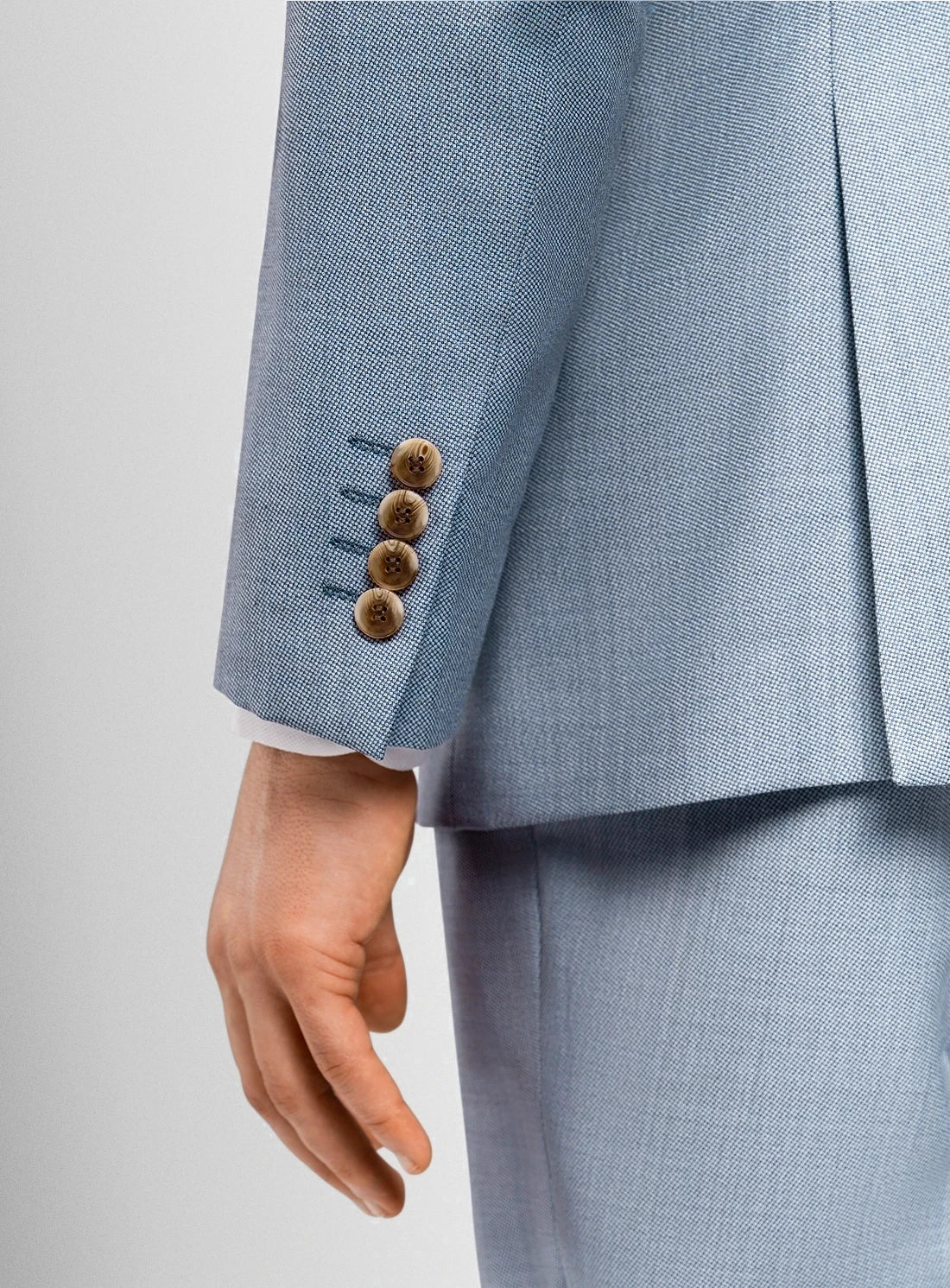 Light blue suit jacket with three buttons on a light gray background