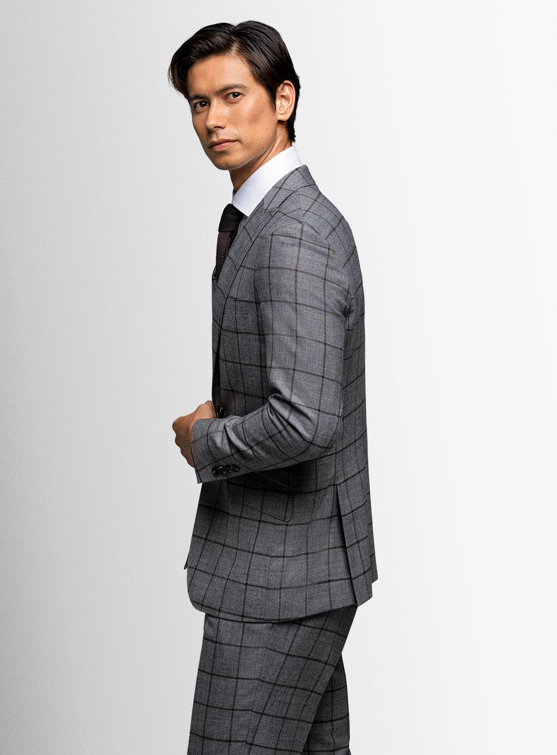 Man wearing a gray checkered suit on a white background