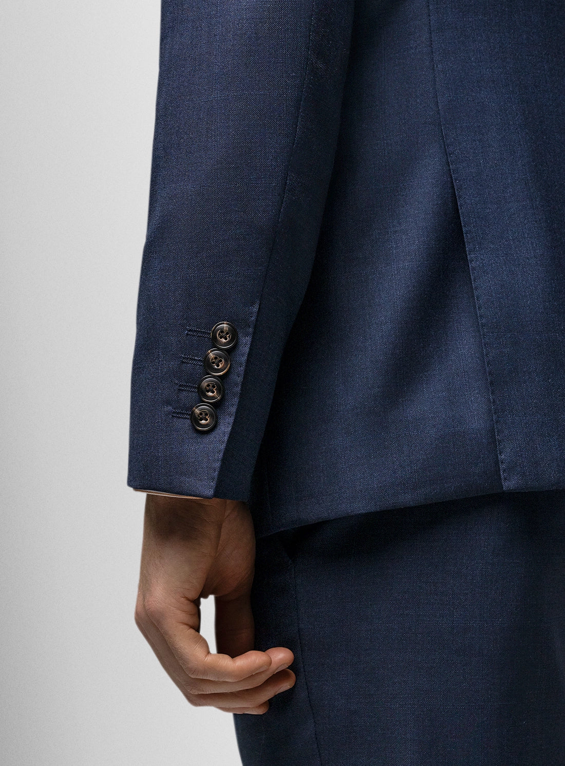 Navy blue suit jacket with buttons on a light gray background