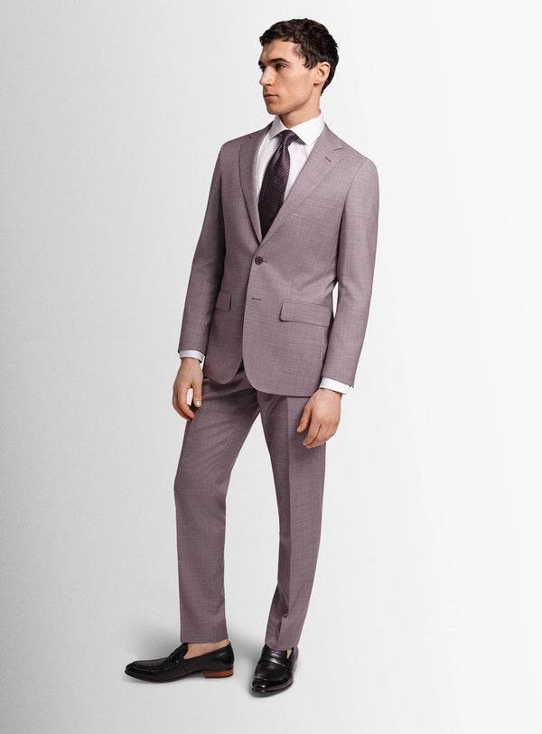 Man wearing a gray suit with a white shirt and black shoes on a light gray background