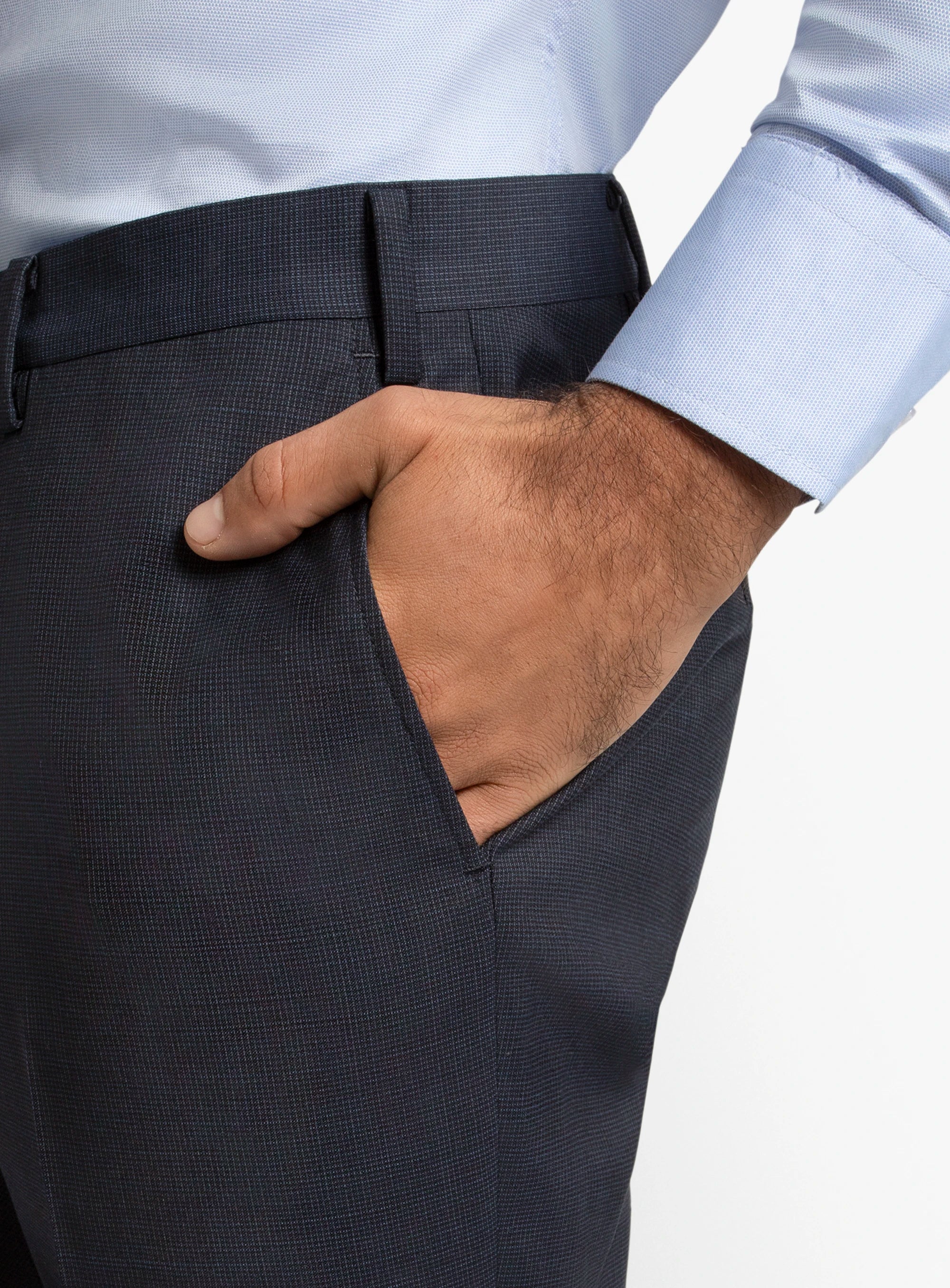 Close-up of a person wearing dark gray dress pants with a light blue shirt.