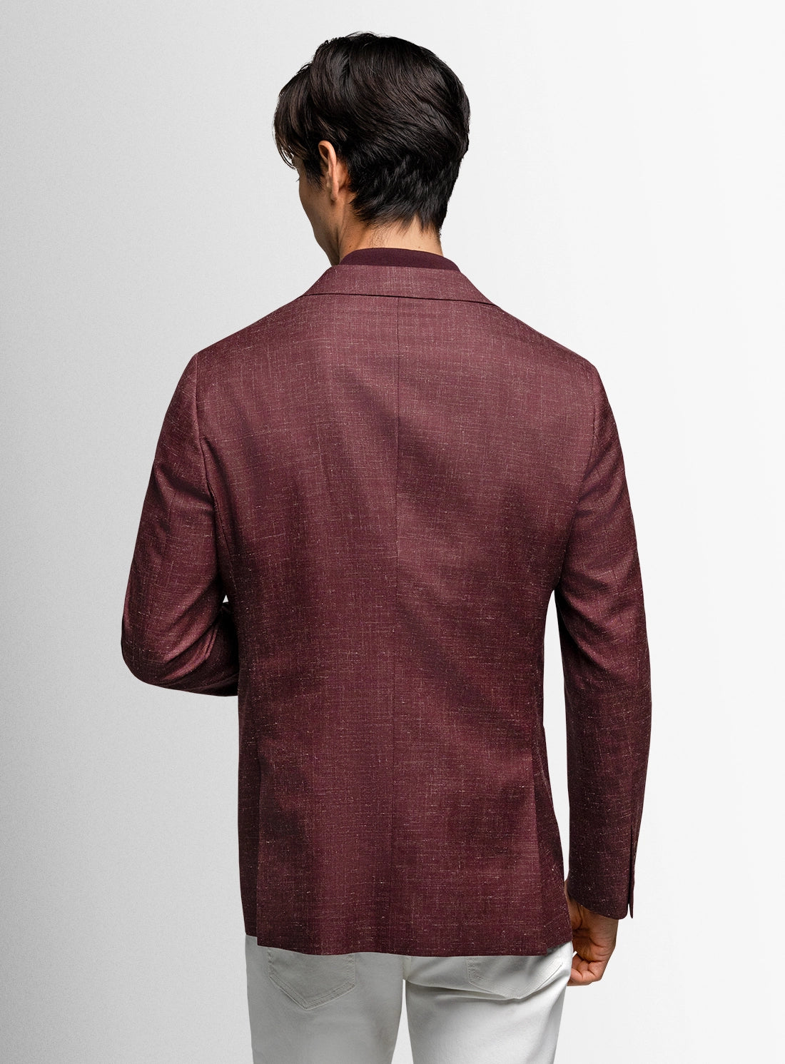 Man wearing a burgundy blazer on a plain background