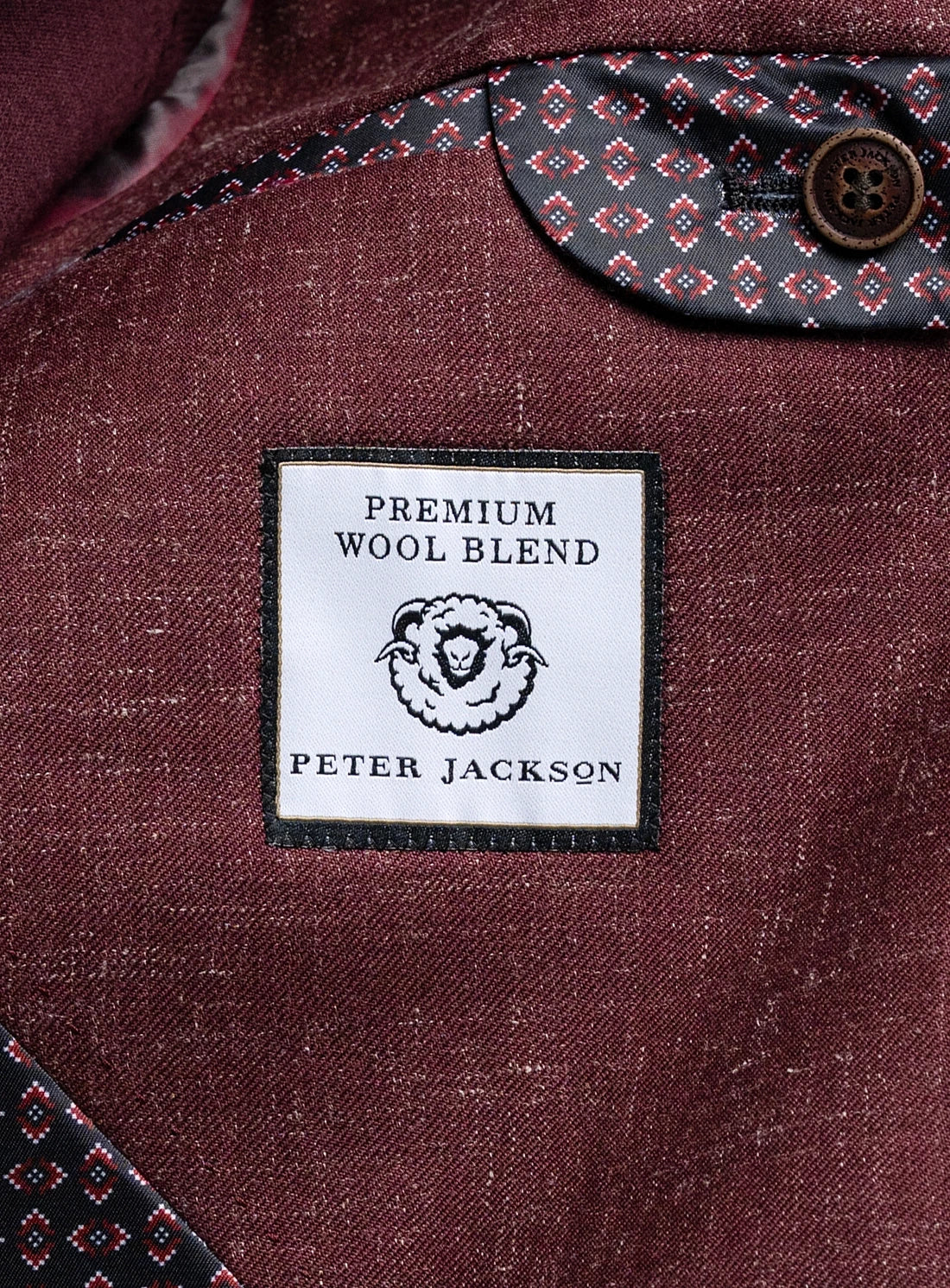 Close-up of a premium wool blend label on a textured fabric surface with a button.