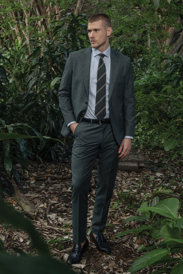 Man in a suit standing in a forest setting