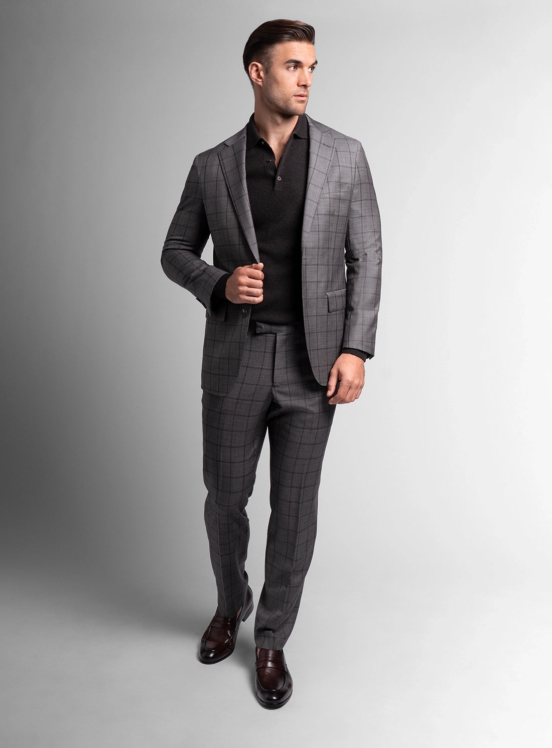 Man wearing a gray checkered suit on a plain background