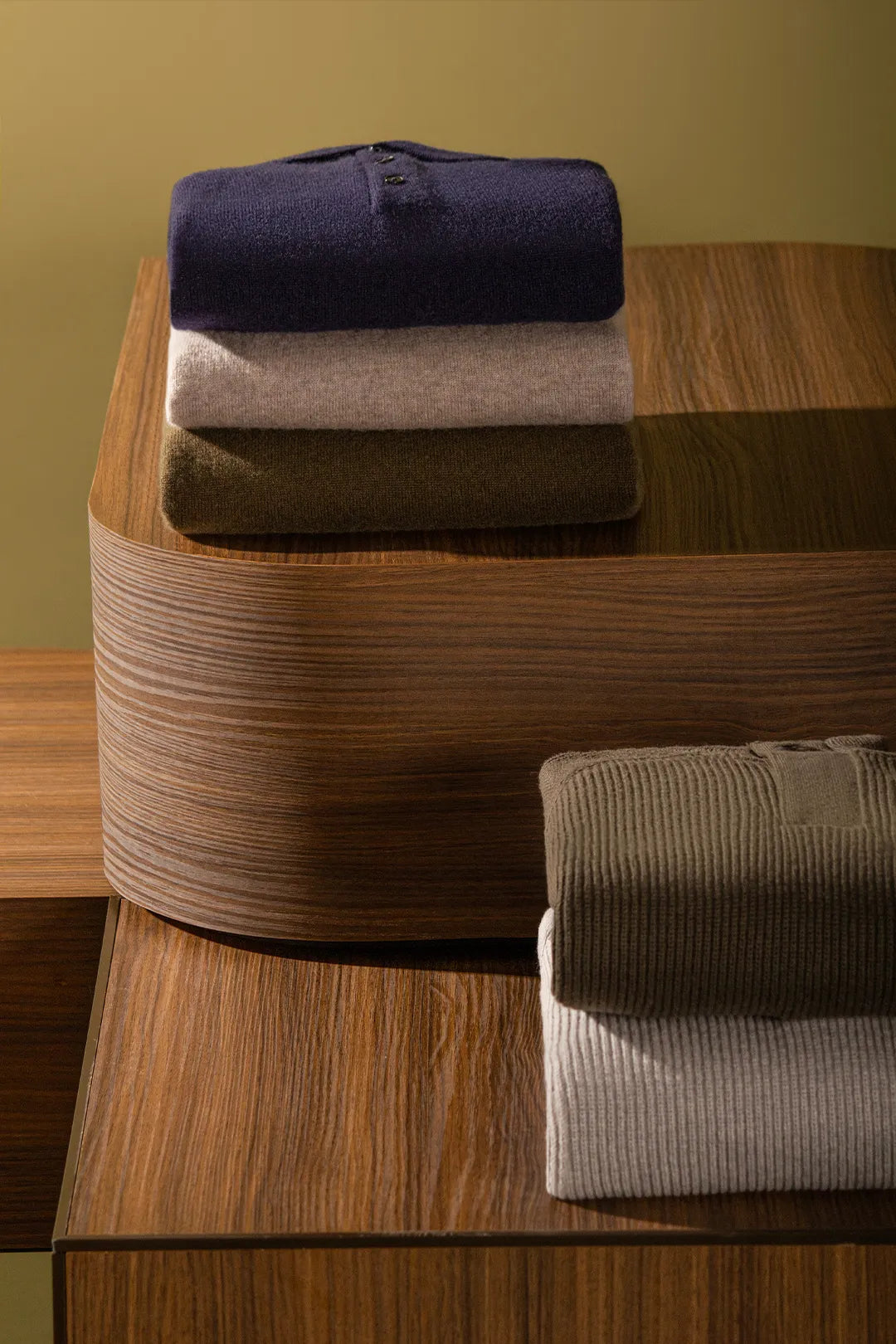Folded shirts sitting over a wooden box