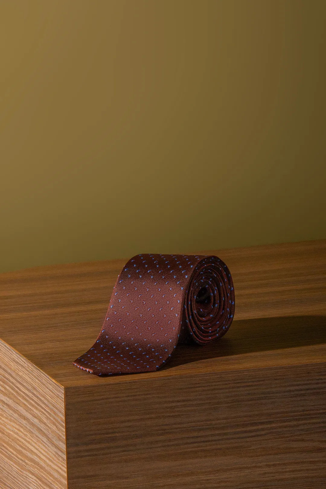 A rolled up neck tie over a wooden box