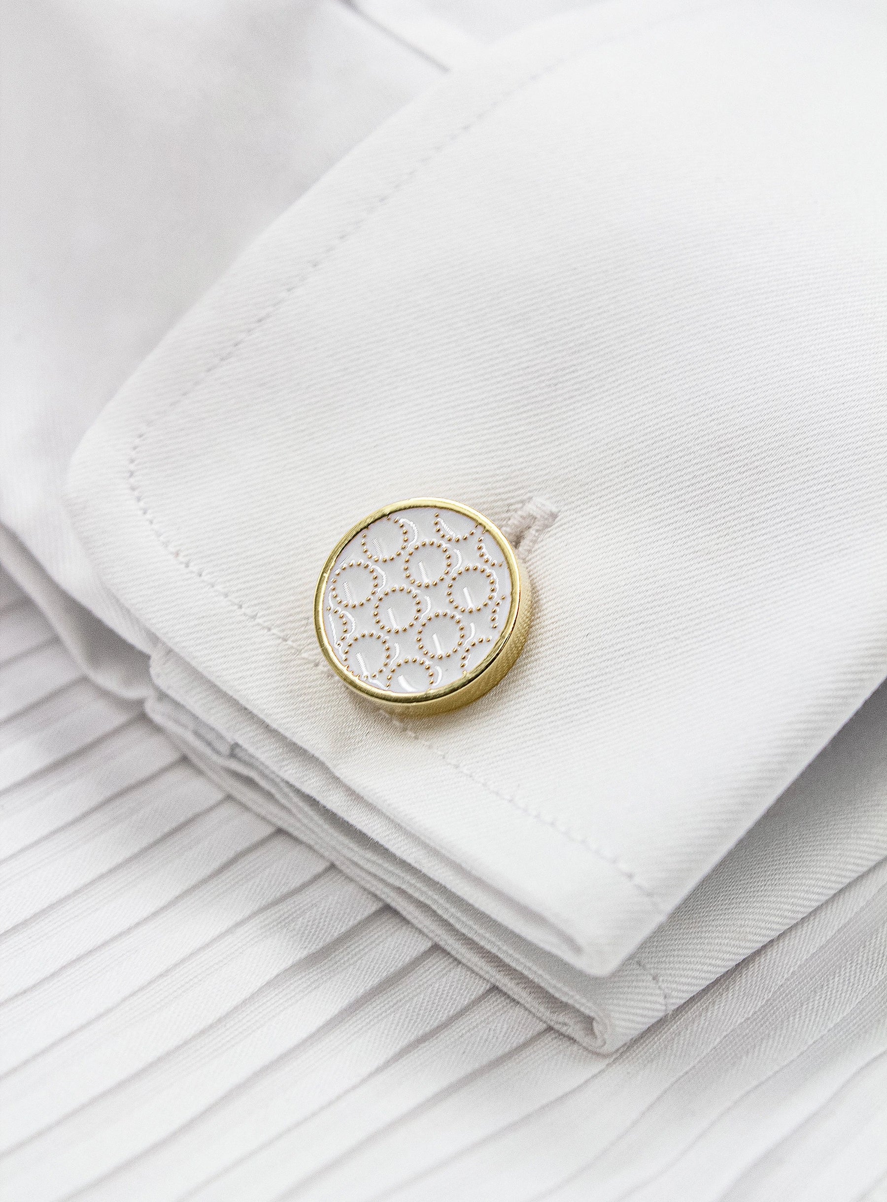 circular gold with white enamel detailed cufflinks in shirt