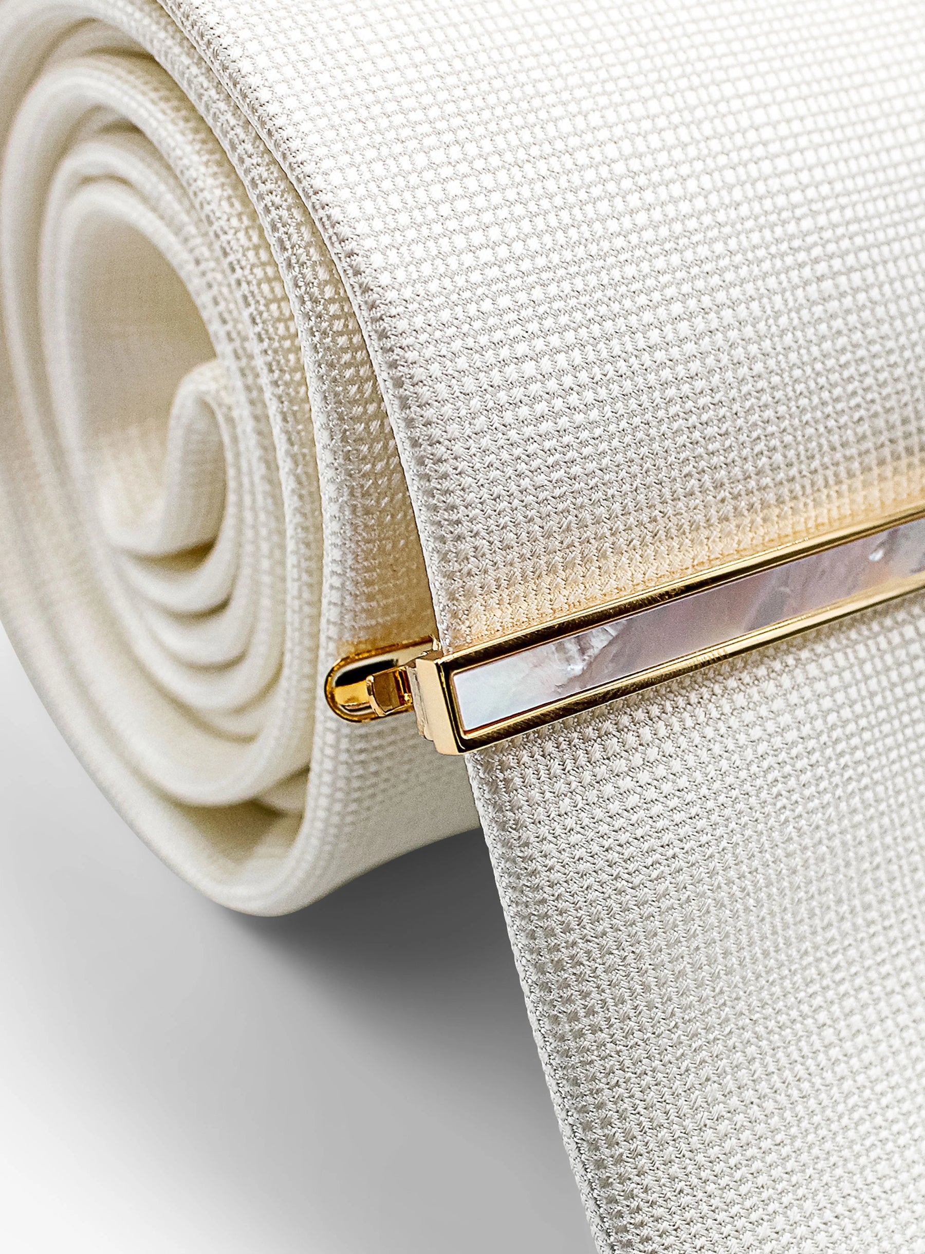 gold with mother of pearl tie bar on tie