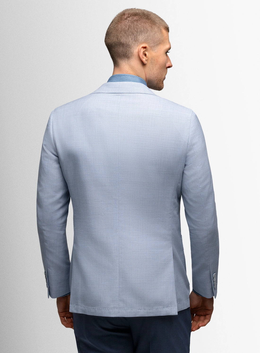 Man wearing a light blue blazer on a plain background