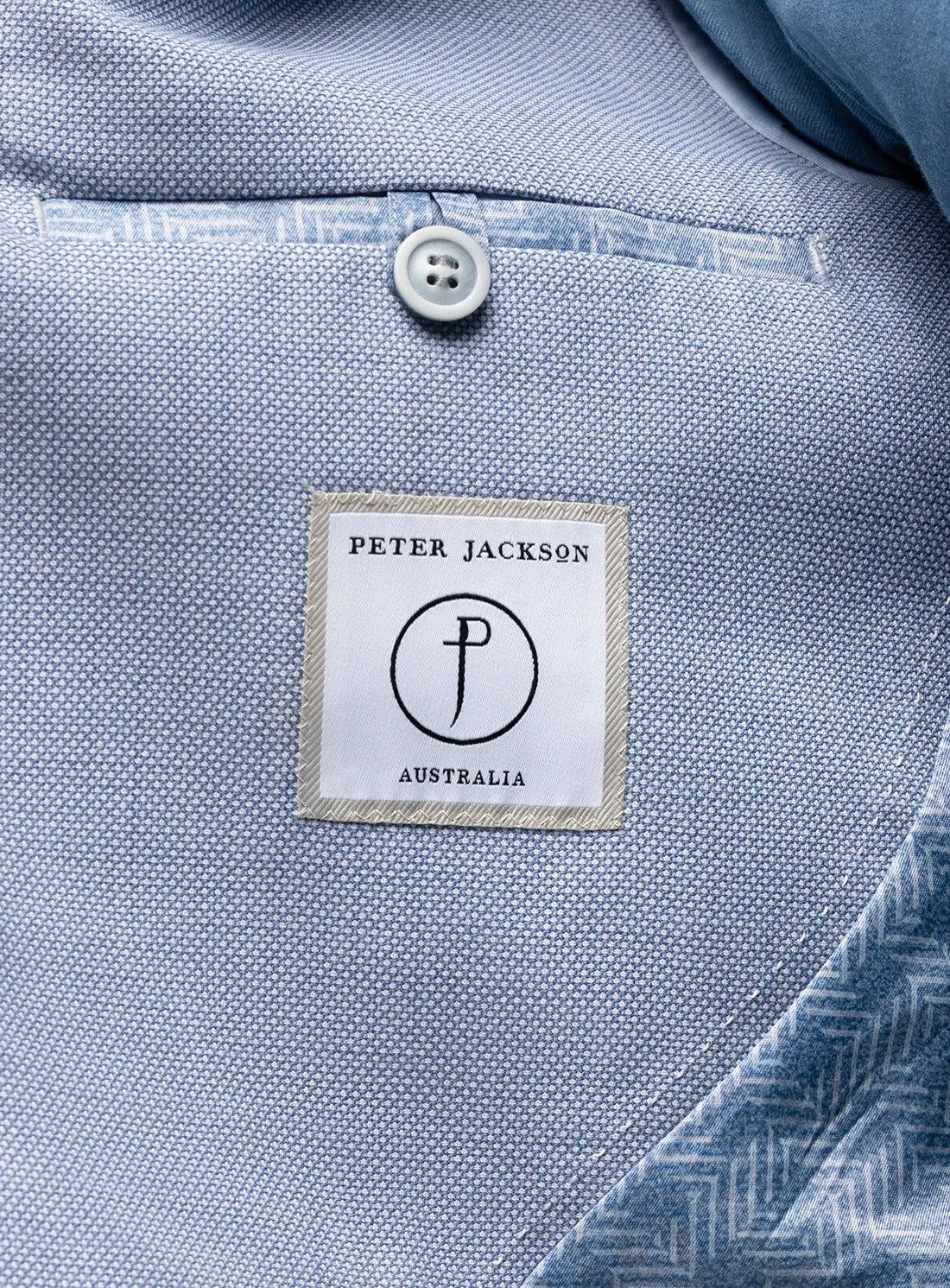 Close-up of a blue textured fabric with a Peter Jackson Australia label.