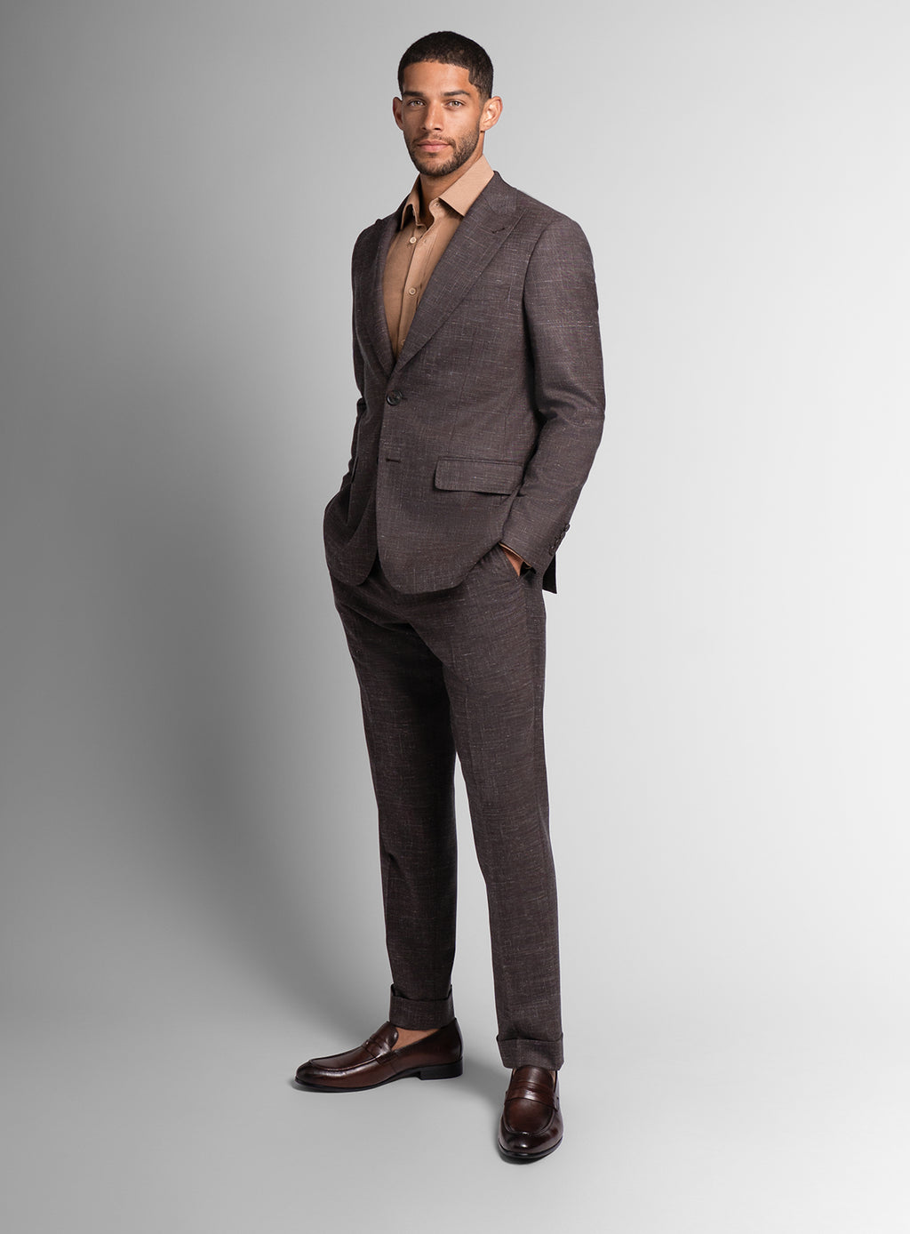 Man wearing a brown suit with a plain background