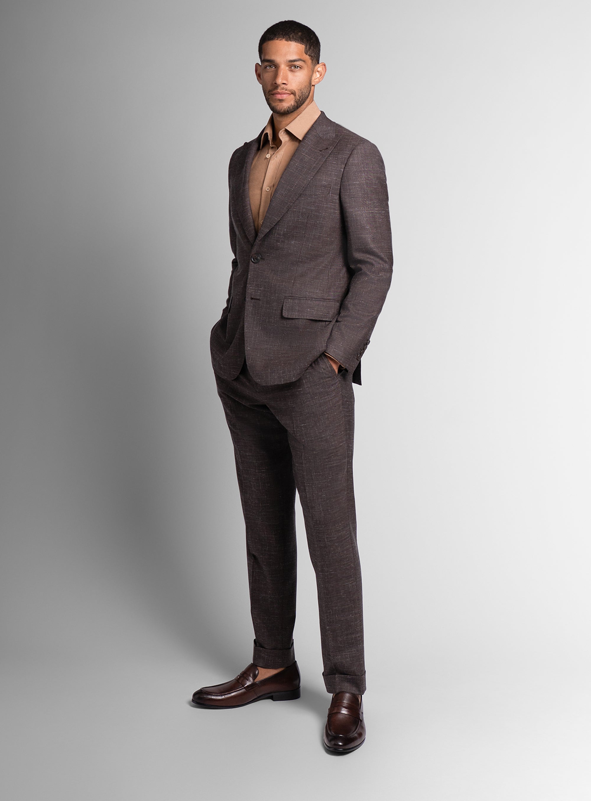 Man wearing a brown suit with a plain background