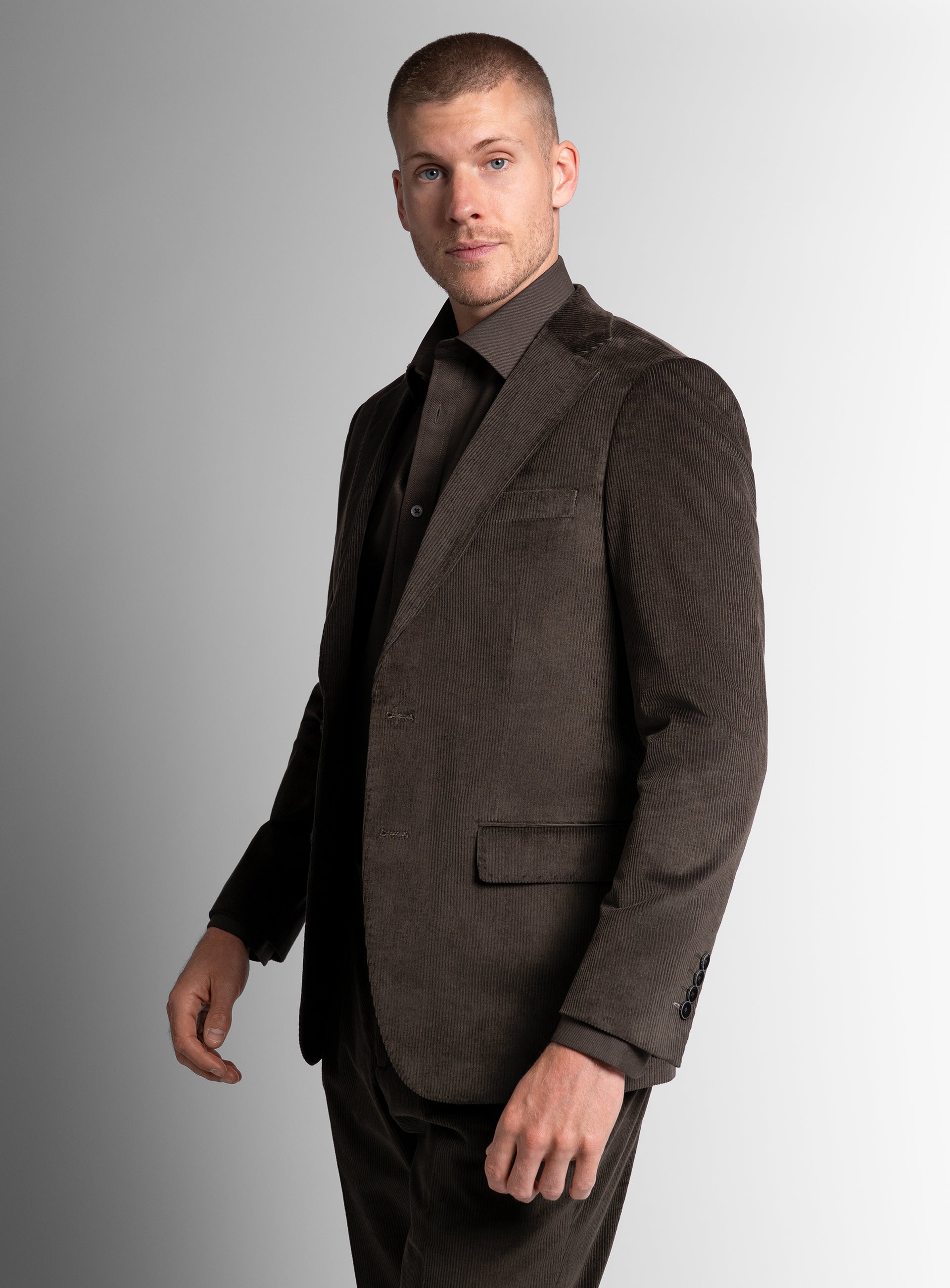 Man standing to his side while wearing the Vitale Corduroy Olive Green Sport Jacket