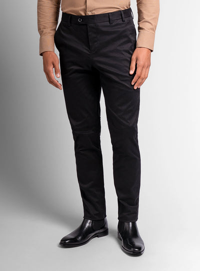Person wearing black pants and black shoes on a gray background