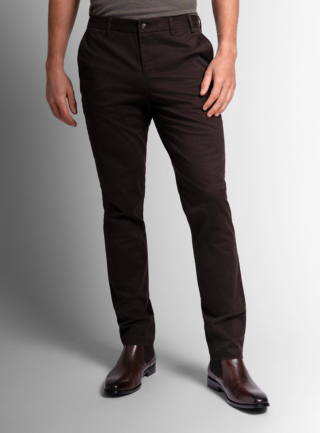 Person wearing dark brown pants on a gray background