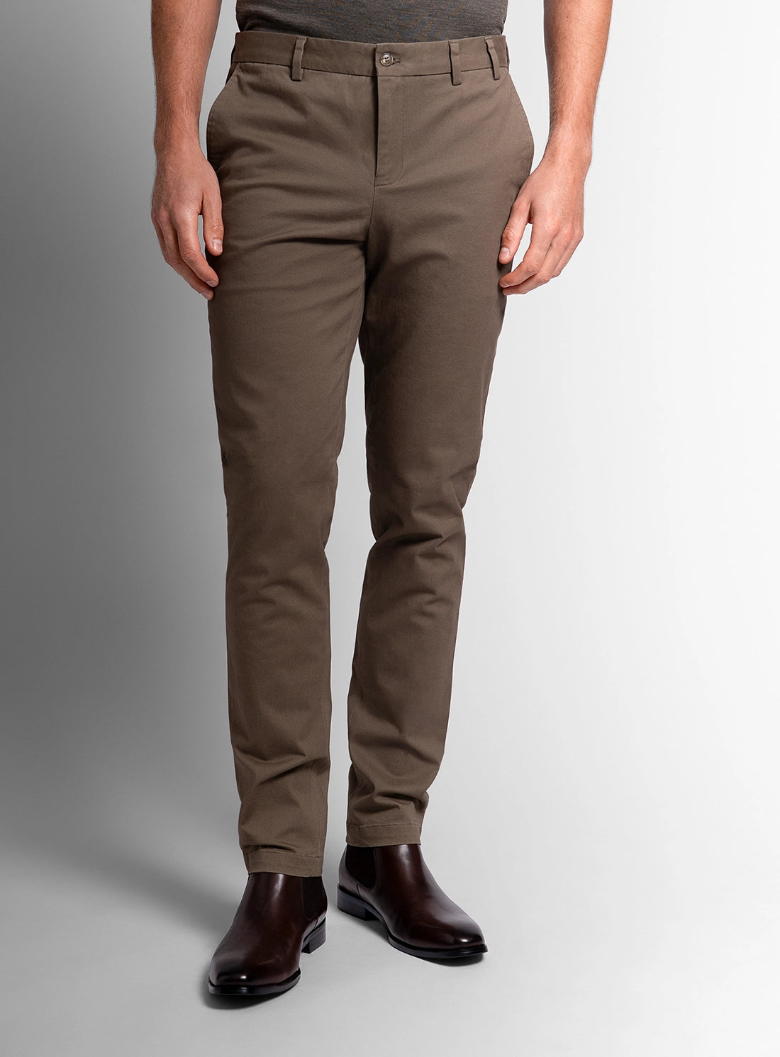 Person wearing brown pants on a gray background