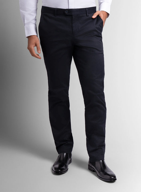 Person wearing black dress pants with a plain background