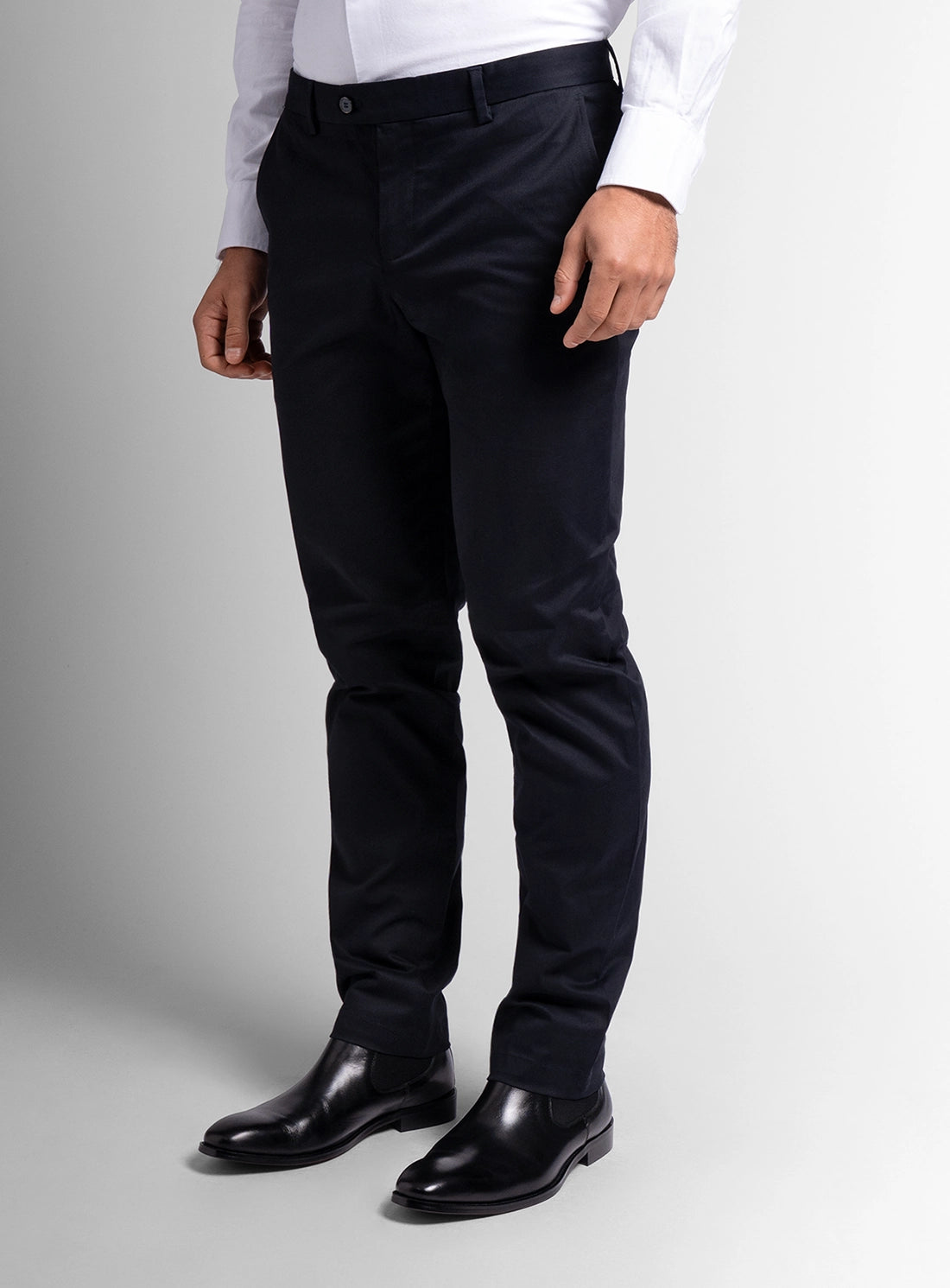 Person wearing black dress pants and black shoes on a light gray background