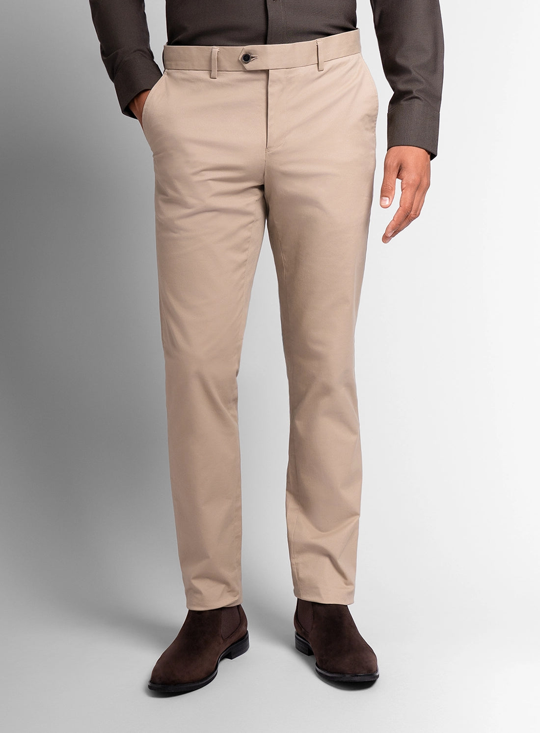 Beige pants worn by a person on a plain background