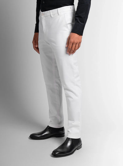 Person wearing white pants and black shoes on a gray background