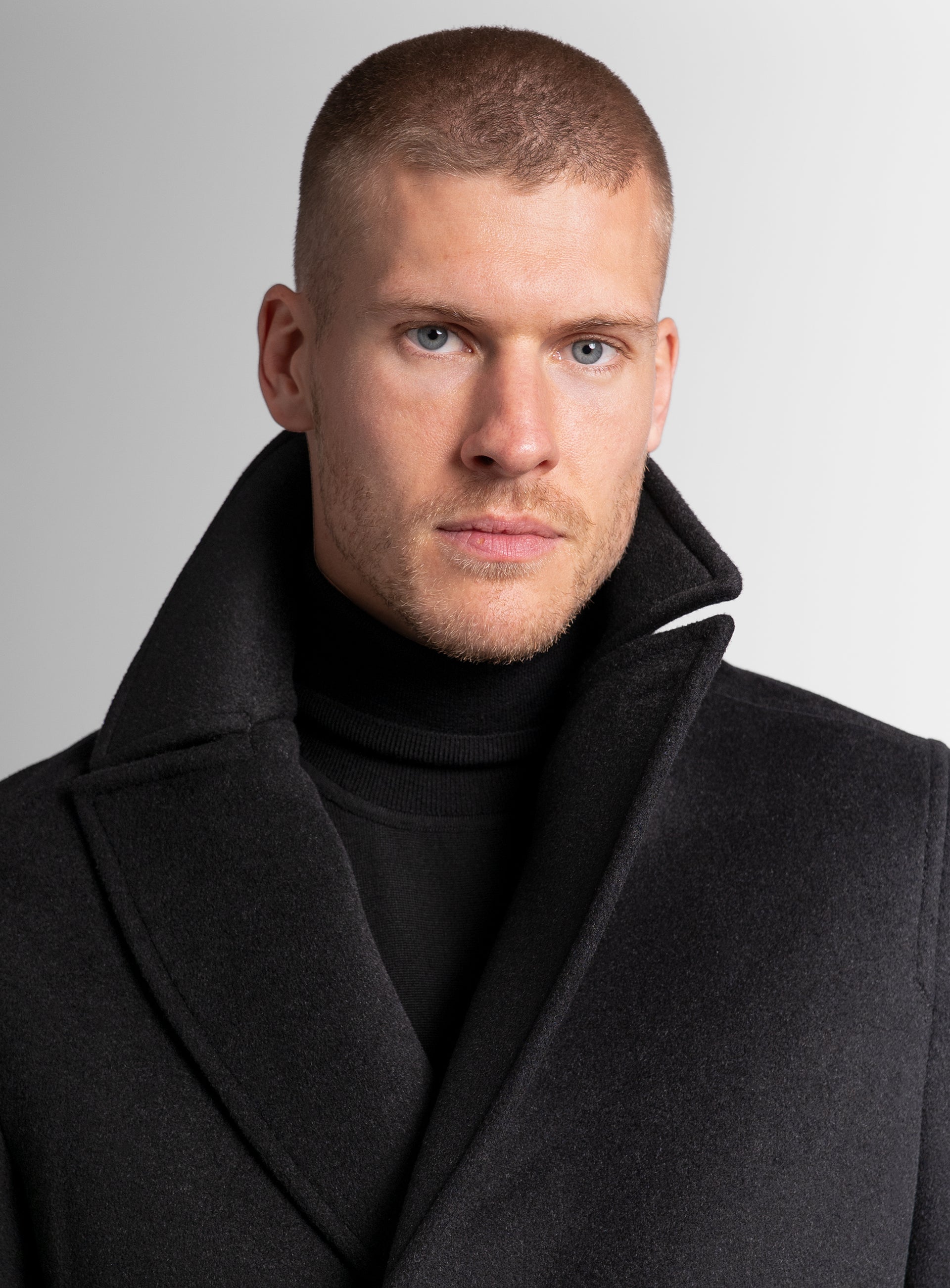 Close-up of a man wearing the Bridge Black Peacoat