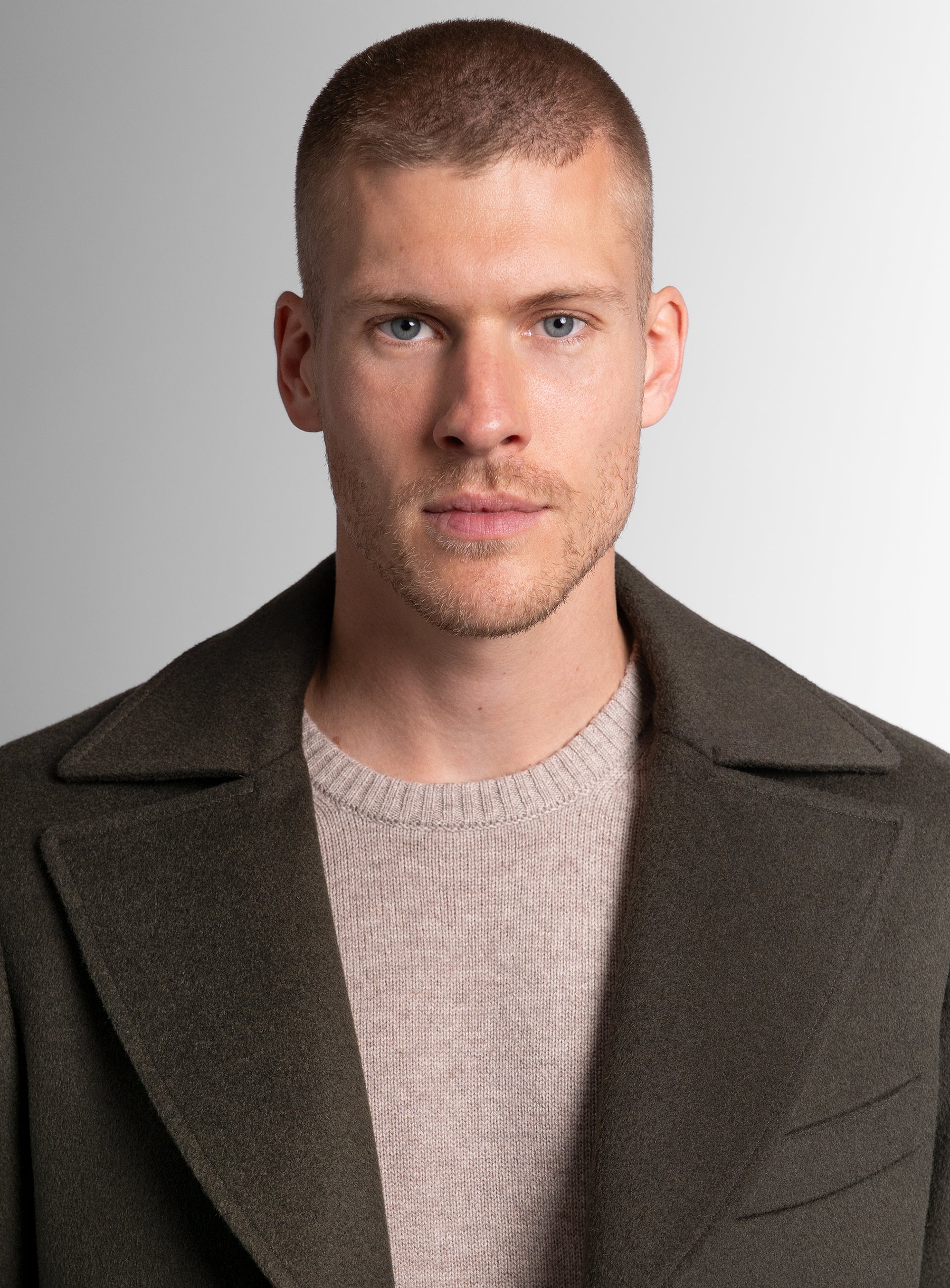 A close-up of a man wearing the Gallio Wool Pile Forest Green Coat