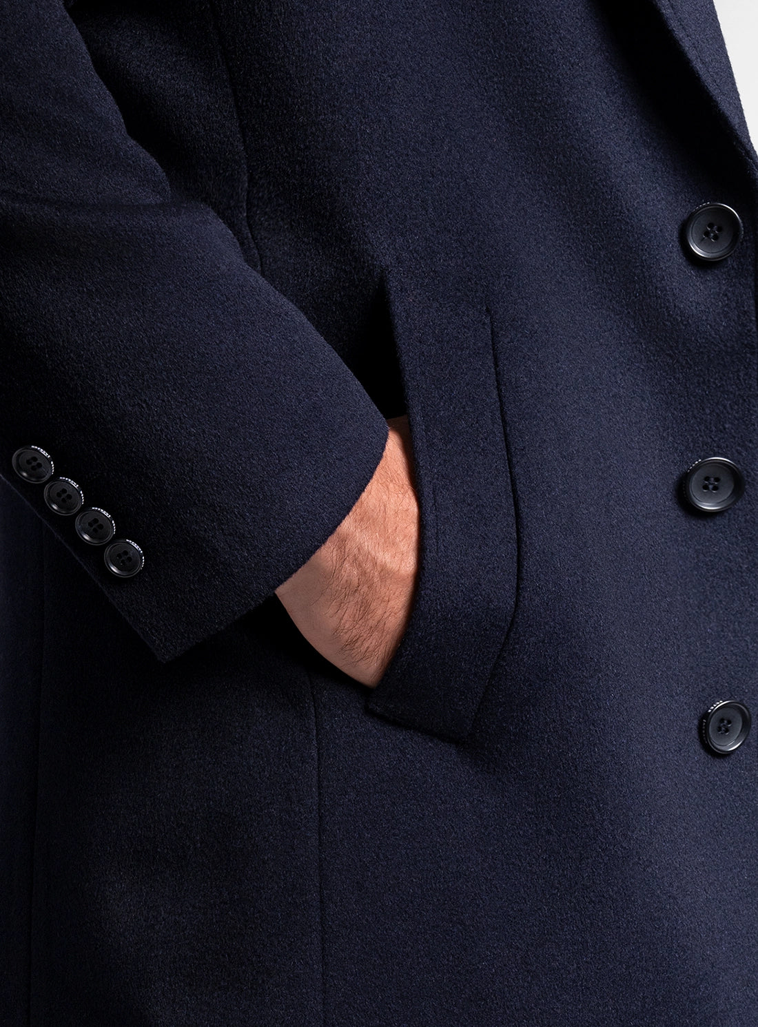 Close-up of a man wearing the Signature Wool Pile Navy Blue Coat with his hand in his pocket
