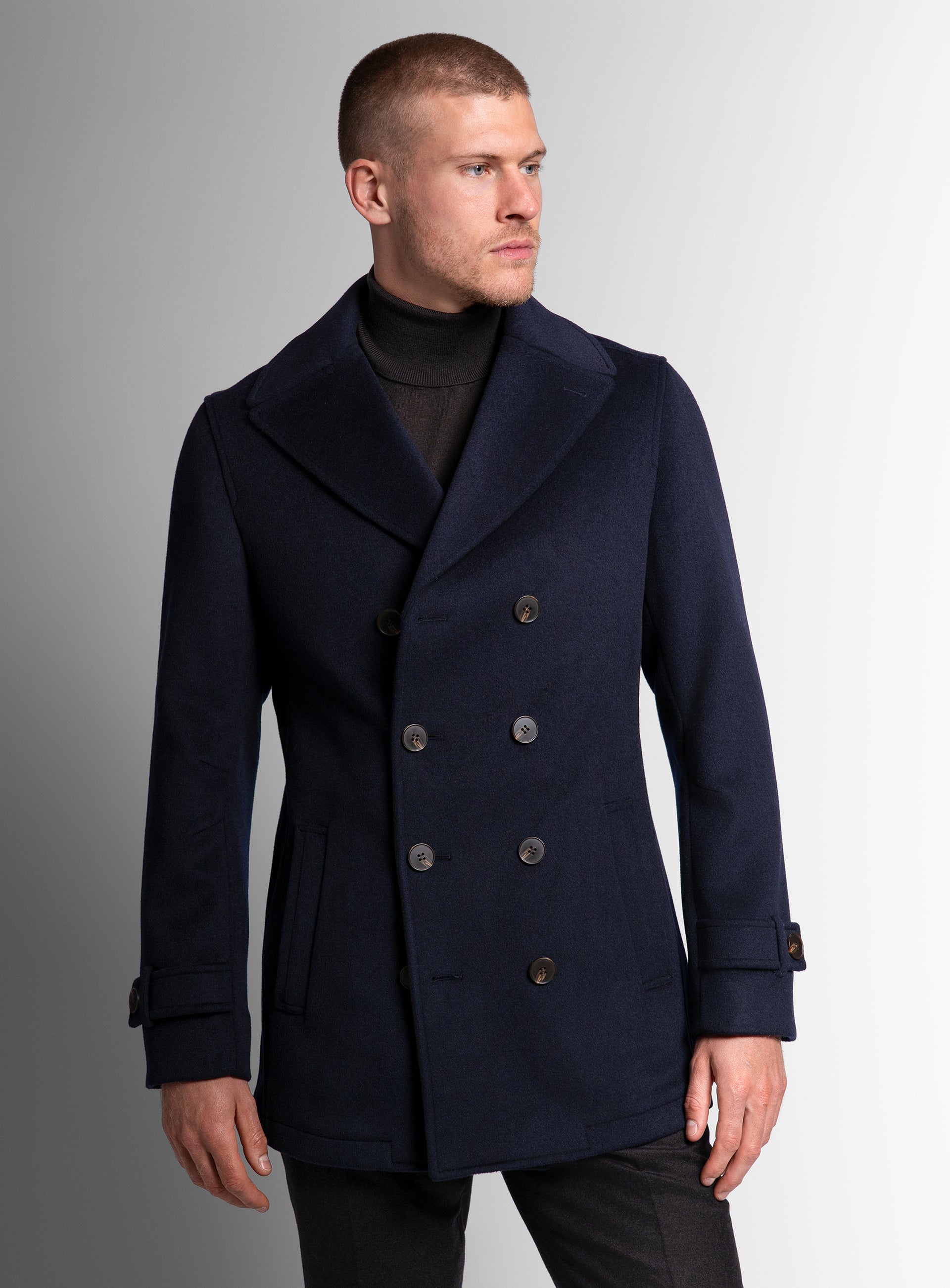 A man wearing the Bridge Navy Blue Peacoat looking to his side