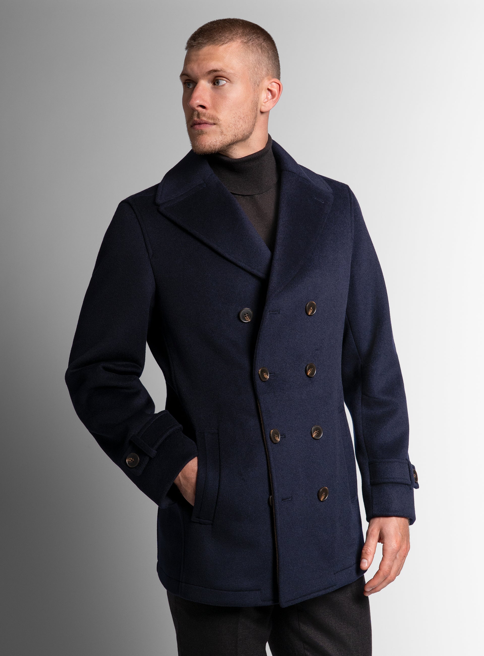 A man wearing the Bridge Navy Blue Peacoat looking to his other side