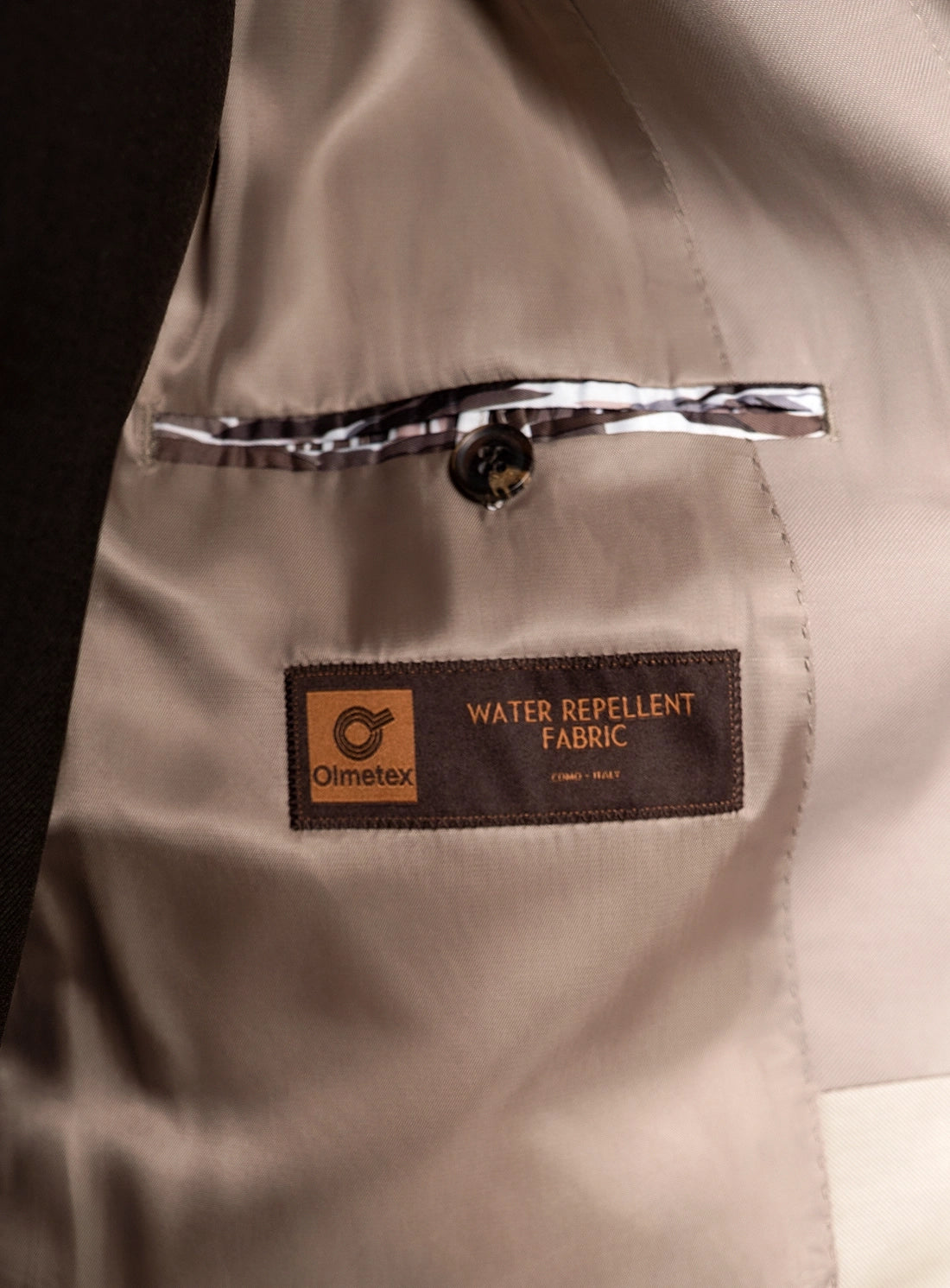 Beige fabric with a water repellent label on a dark background