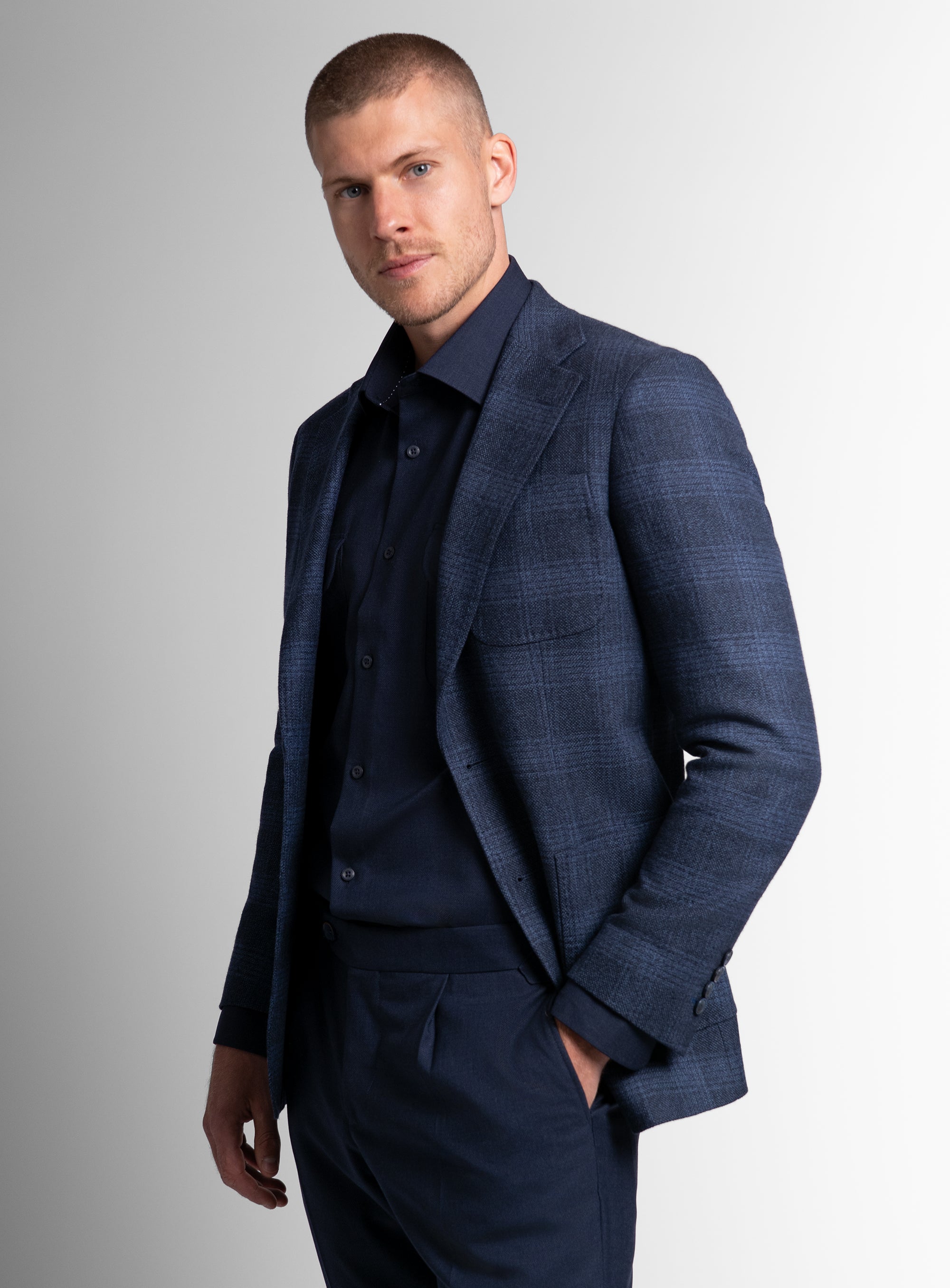 Man to his side wearing the Luzio Milled Plaid Navy Jacket