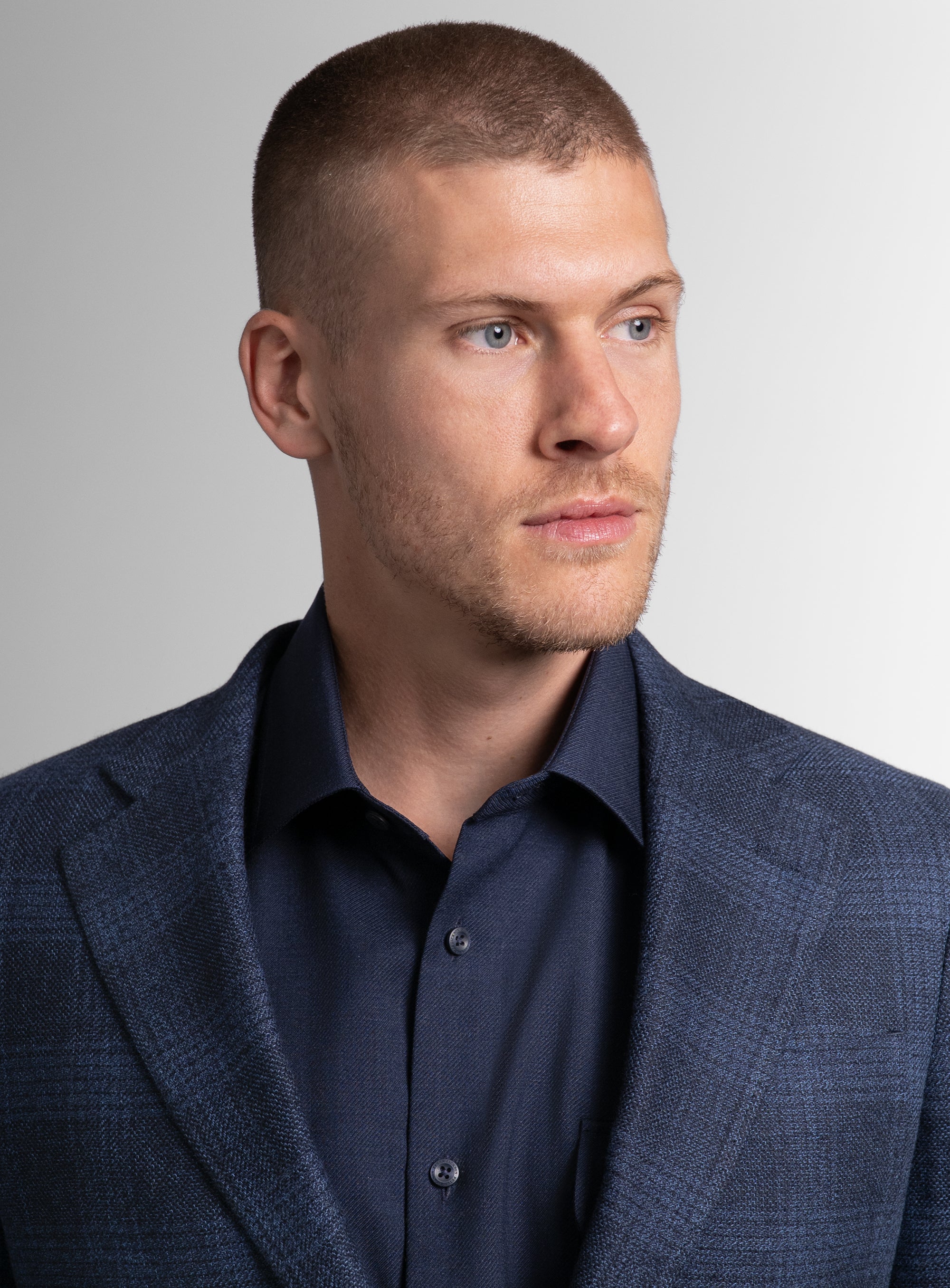 Close-up of man wearing the Luzio Milled Plaid Navy Jacket