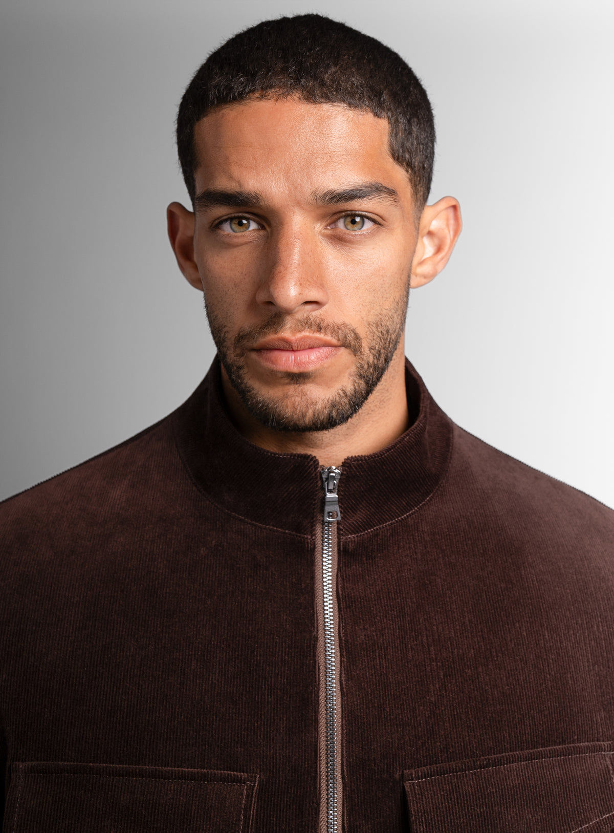A close-up of a man wearing the Aldor Corduroy Chocolate Brown Jacket