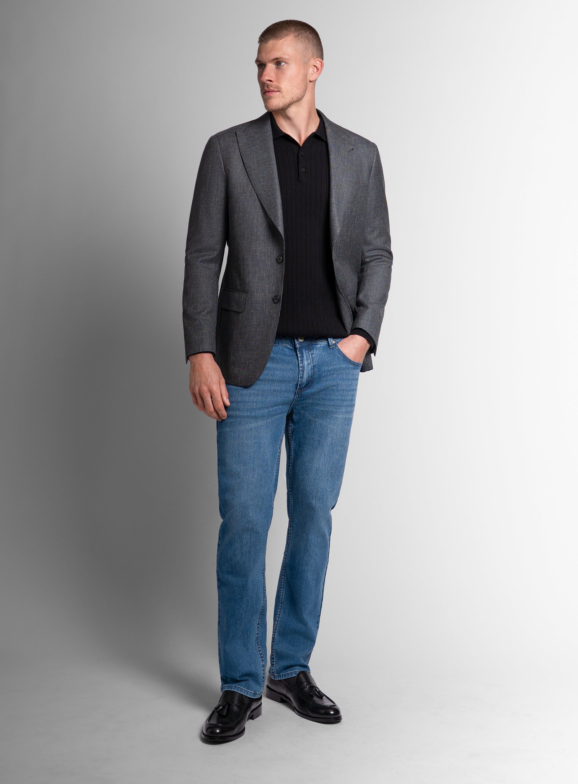 A man wearing the Portici Puppytooth Green Jacket with his hand in his pocket