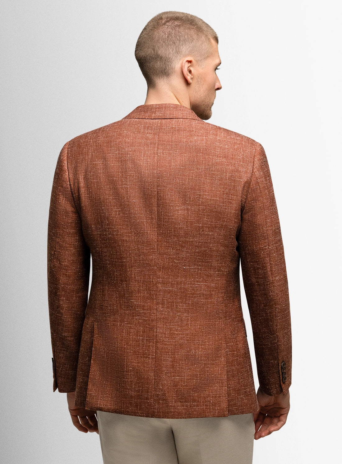Man wearing a brown blazer on a plain background