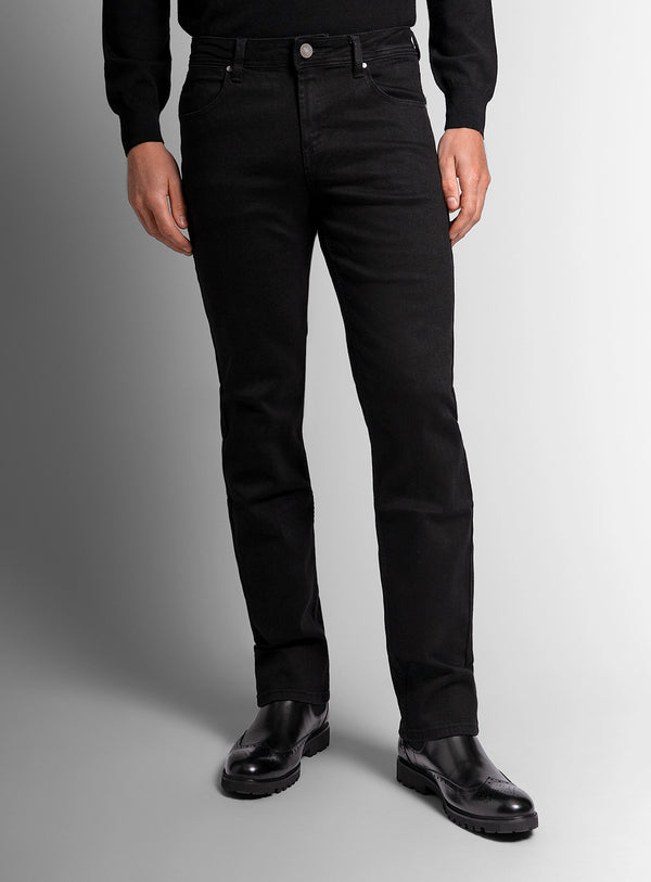 Person wearing black jeans and black shoes on a gray background