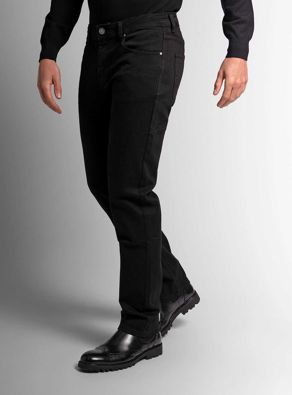 Person wearing black pants and shoes on a gray background